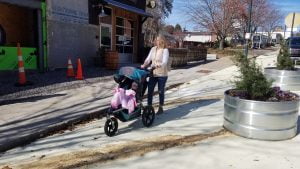 Mom pushing stroller in multi-use path on Coxe Ave