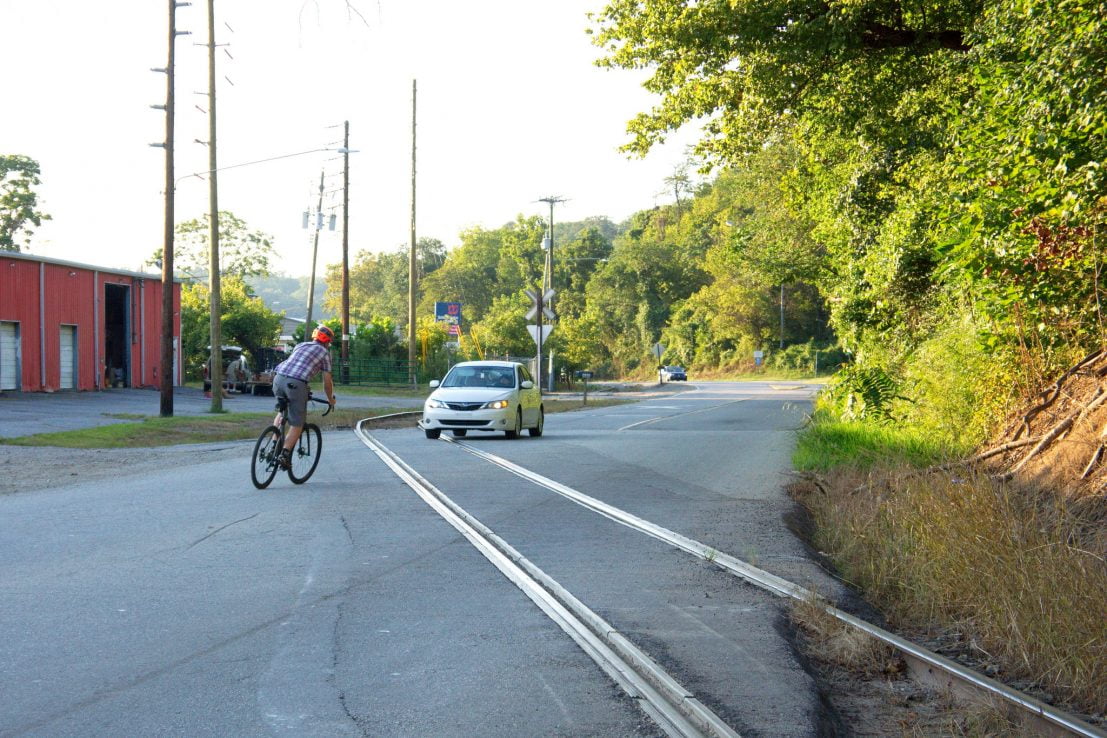 Asheville, Riverside Drive, northbound cyclist attempts to cross RR tracks by veering into oncoming traffic