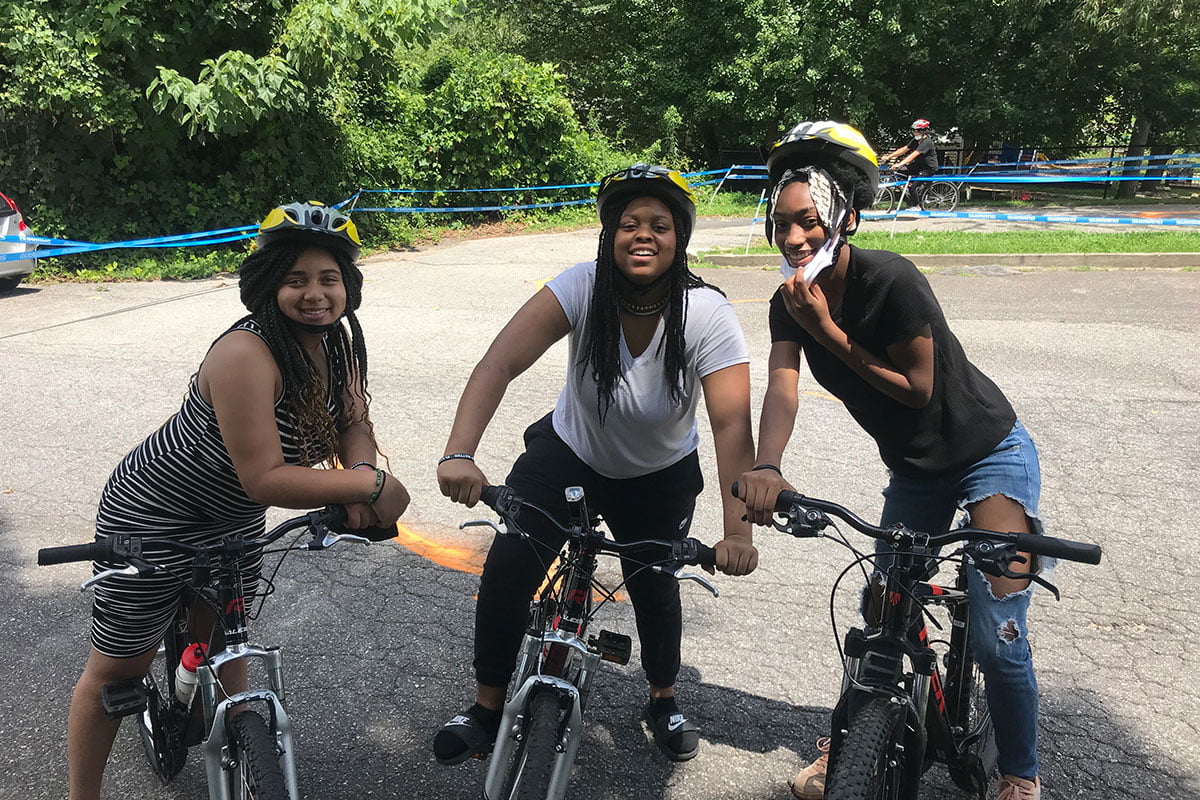 Three Girls Smiling on Bikes