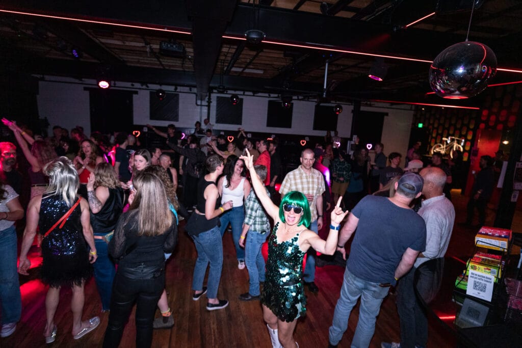 People smiling on the dancefloor at Bike Love event by Asheville on Bikes