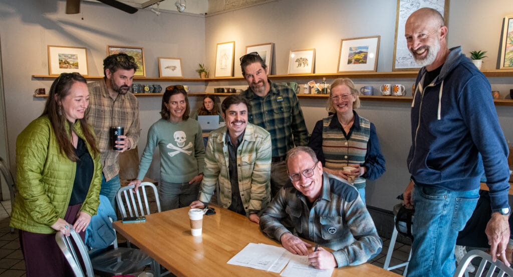 AVL Unpaved Alliance members and City of Asheville staff meet at Ultra Coffee in the River Arts District to sign the AVL Unpaved agreement.