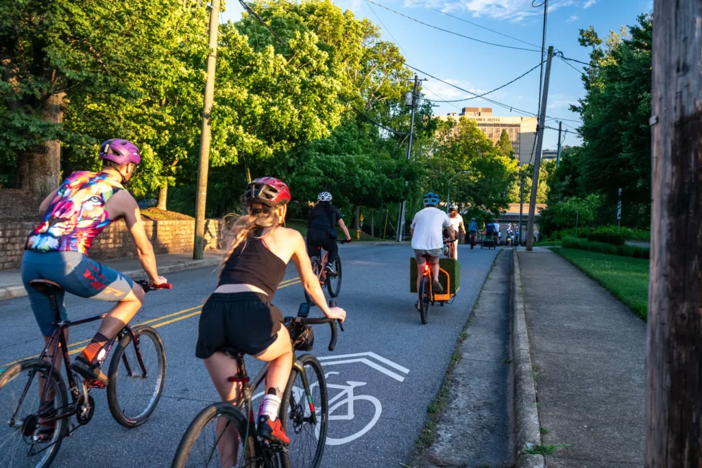 Cyclists riding down Asheville street towards downtown.